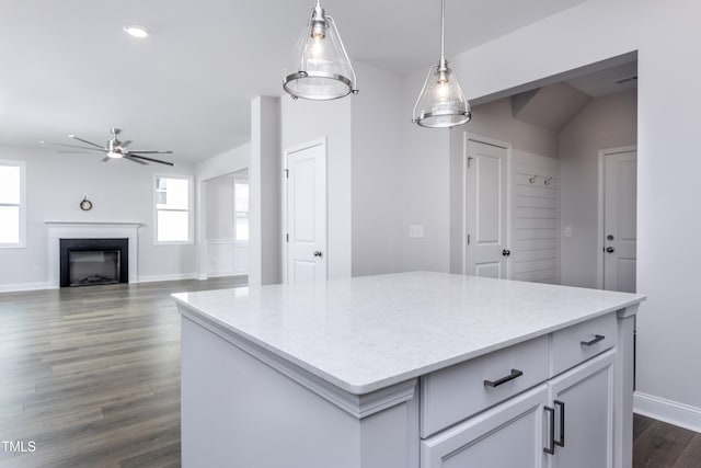 kitchen with pendant lighting, a fireplace, dark wood-style flooring, and light countertops