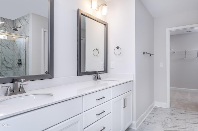 bathroom featuring a sink, a marble finish shower, baseboards, and marble finish floor