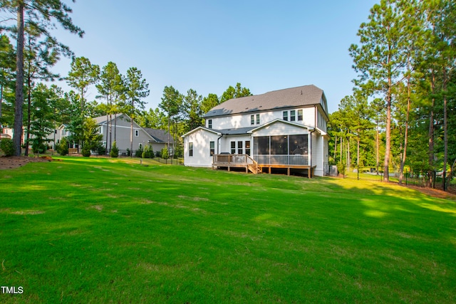 rear view of property with a yard and a sunroom