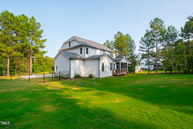 back of house featuring a lawn and a sunroom