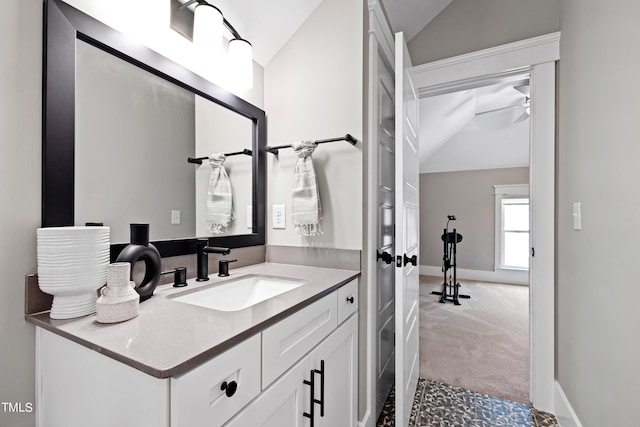 bathroom featuring vaulted ceiling, ceiling fan, and vanity