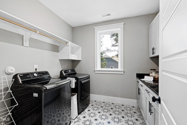 laundry area featuring washer and clothes dryer and cabinets