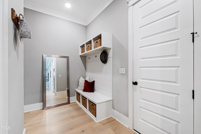 mudroom featuring light wood-type flooring and crown molding