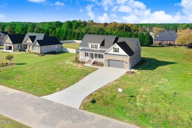 46 Otter Hole Dr, Kenly, NC 27542 - view of front facade with a porch, a forest view, a front yard, concrete driveway, and stone siding