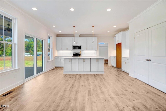 46 Otter Hole Dr, Kenly, NC 27542 - kitchen with crown molding, light countertops, light wood-style floors, and appliances with stainless steel finishes