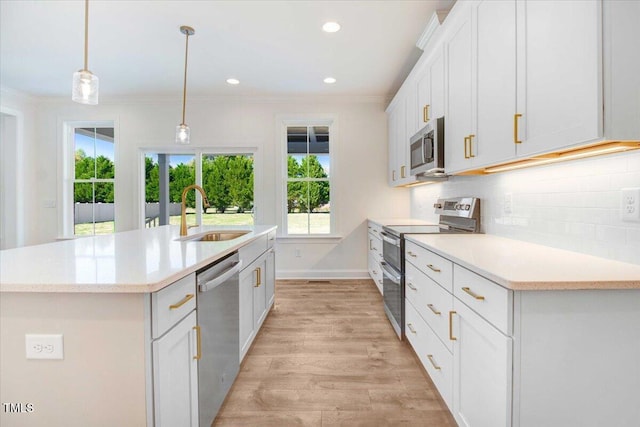 46 Otter Hole Dr, Kenly, NC 27542 - kitchen with crown molding, a center island with sink, a sink, light countertops, and stainless steel appliances