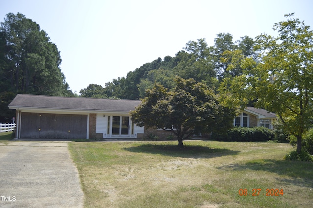 single story home featuring a garage and a front yard