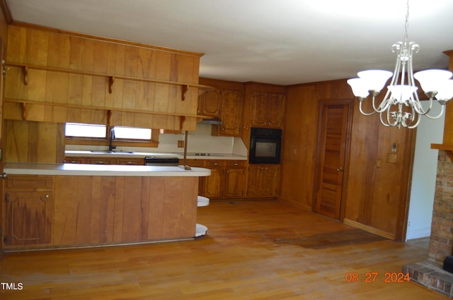 kitchen featuring black appliances, light wood-type flooring, and a chandelier