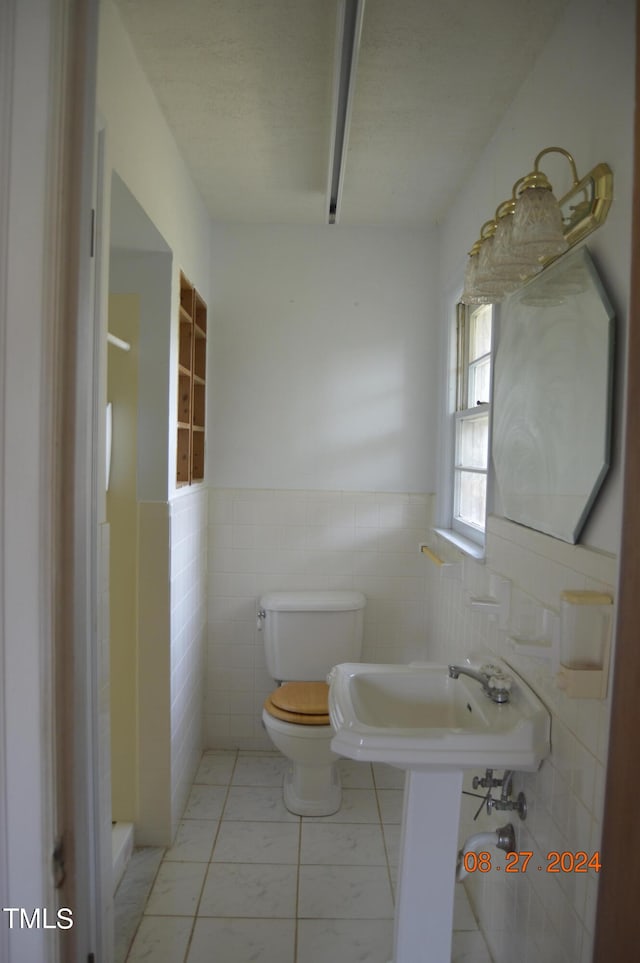 bathroom featuring tile walls and toilet