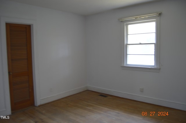 unfurnished bedroom with a closet, multiple windows, and light hardwood / wood-style floors