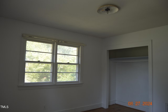 unfurnished bedroom featuring a closet and multiple windows