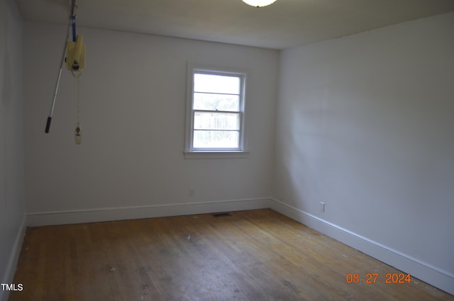 unfurnished room with hardwood / wood-style flooring