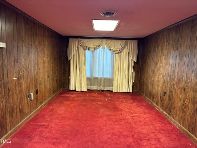 carpeted spare room featuring wooden walls