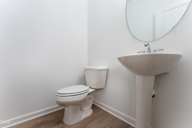 bathroom with hardwood / wood-style flooring and toilet