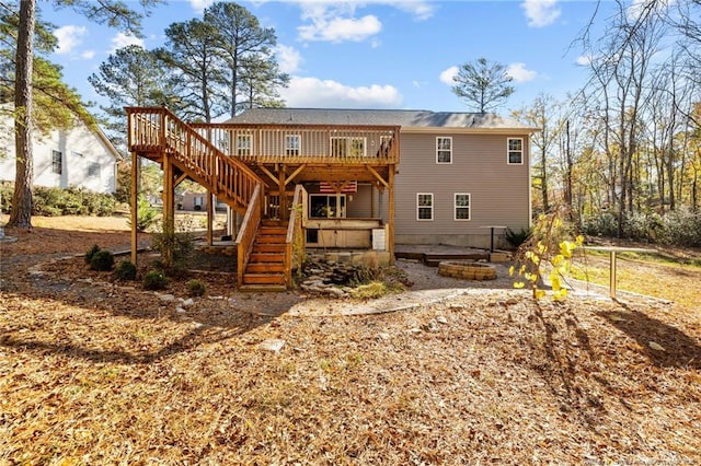 rear view of house with a deck and a fire pit