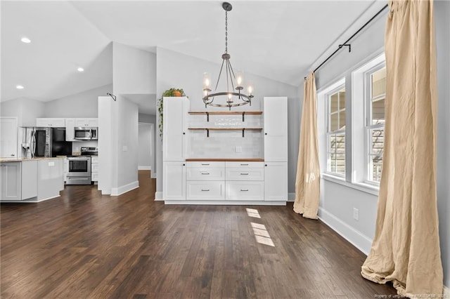 unfurnished dining area with lofted ceiling, dark wood-type flooring, and a chandelier