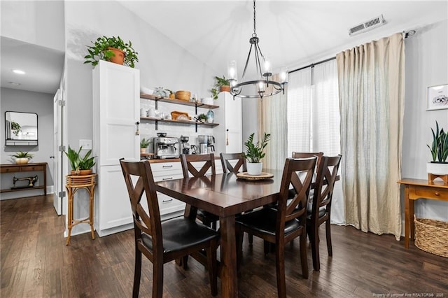 dining space featuring dark wood-type flooring and a notable chandelier