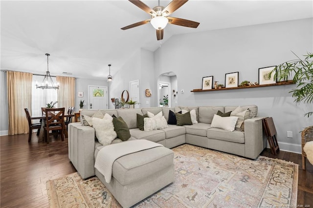 living room with hardwood / wood-style flooring, ceiling fan with notable chandelier, and high vaulted ceiling