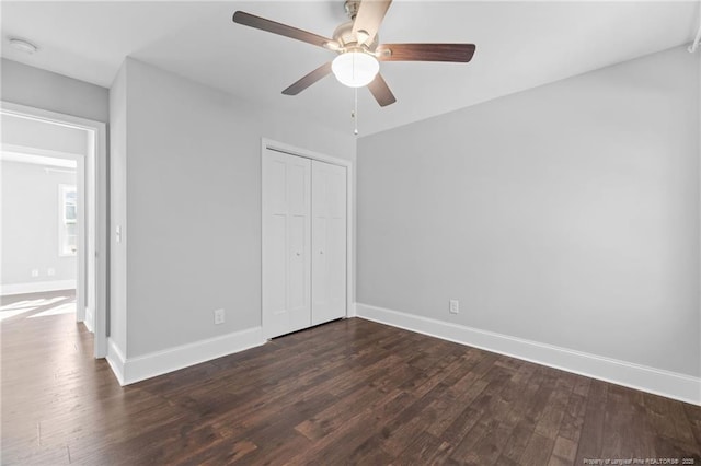 unfurnished bedroom with dark wood-type flooring, ceiling fan, and a closet