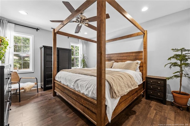 bedroom with multiple windows, dark hardwood / wood-style floors, and ceiling fan