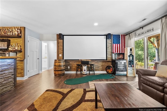 home theater room featuring bar area and hardwood / wood-style floors