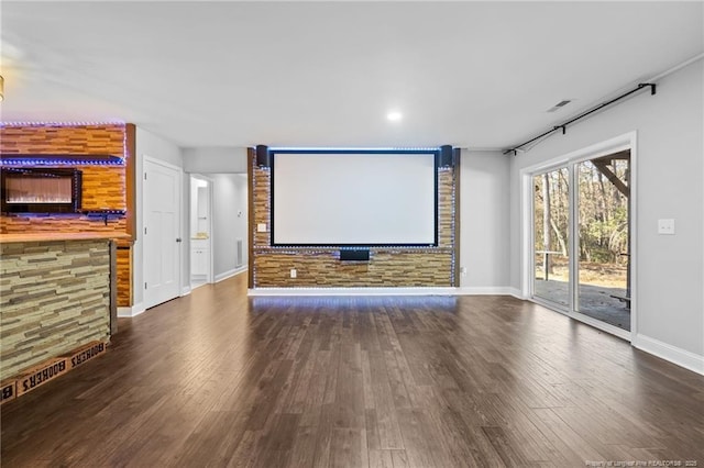 cinema room with dark hardwood / wood-style flooring and bar area