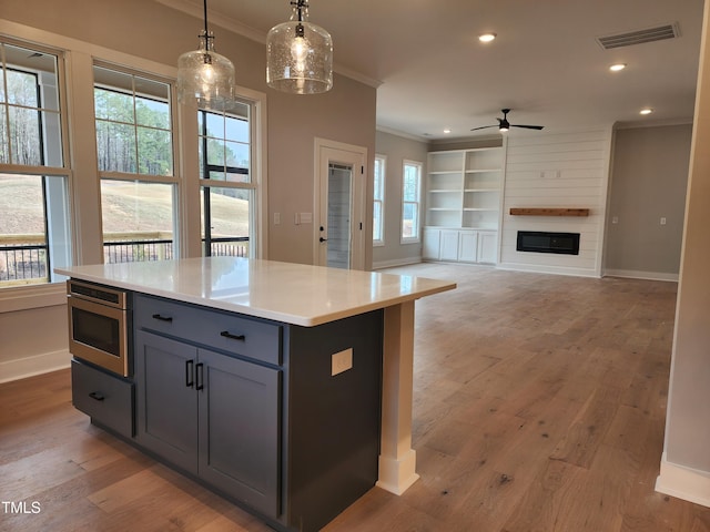 kitchen featuring light wood-type flooring, visible vents, crown molding, and gray cabinetry