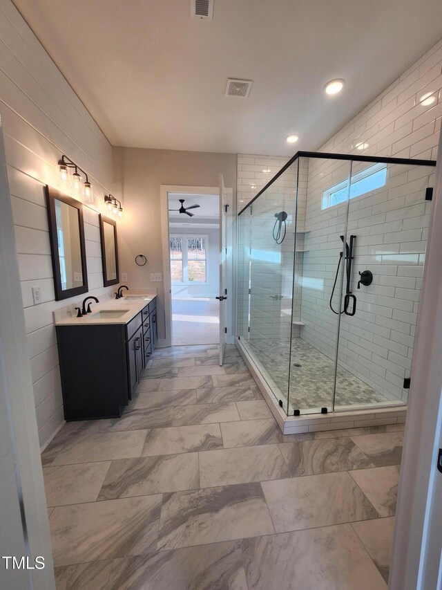 bathroom featuring marble finish floor, double vanity, visible vents, a sink, and a shower stall