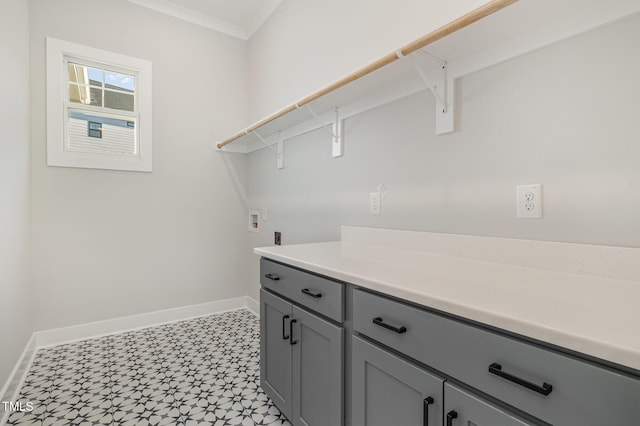 clothes washing area with washer hookup, baseboards, ornamental molding, cabinet space, and light floors