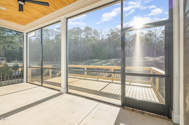 unfurnished sunroom with wooden ceiling and ceiling fan