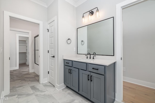 bathroom featuring baseboards, a shower, ornamental molding, marble finish floor, and vanity