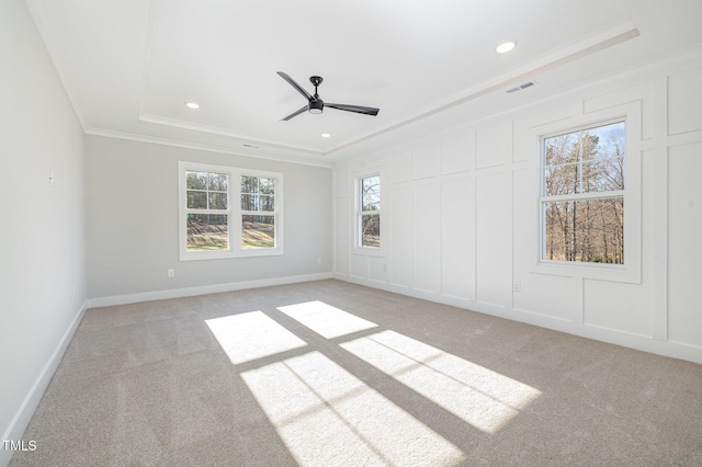 spare room with crown molding, light carpet, and a decorative wall