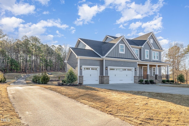 craftsman-style home with board and batten siding, covered porch, brick siding, and concrete driveway