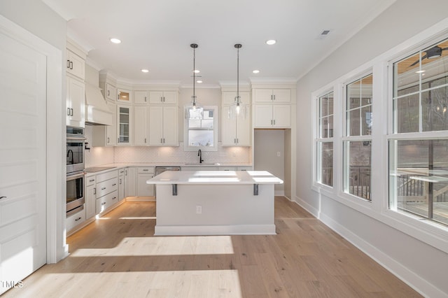 kitchen featuring black electric stovetop, white cabinets, light countertops, backsplash, and glass insert cabinets