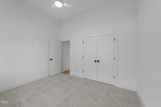 unfurnished bedroom featuring a ceiling fan, carpet, baseboards, and a closet