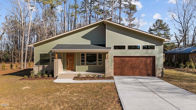 view of front facade with a garage, covered porch, and a front lawn