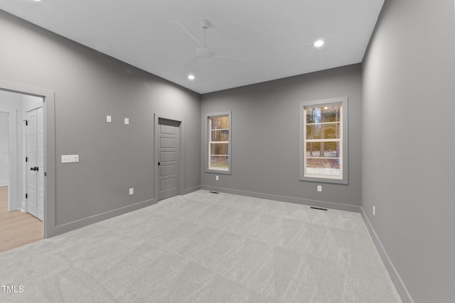 unfurnished room featuring recessed lighting, light carpet, and baseboards