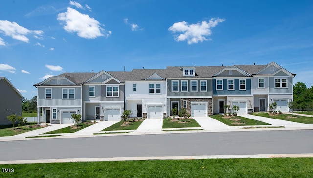 multi unit property featuring an attached garage, driveway, and stone siding
