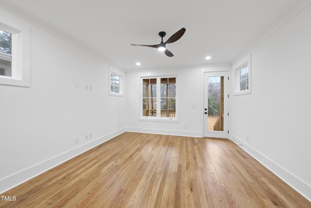 empty room featuring light wood-type flooring, plenty of natural light, and baseboards