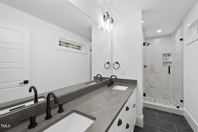 full bath with double vanity, a marble finish shower, and a sink