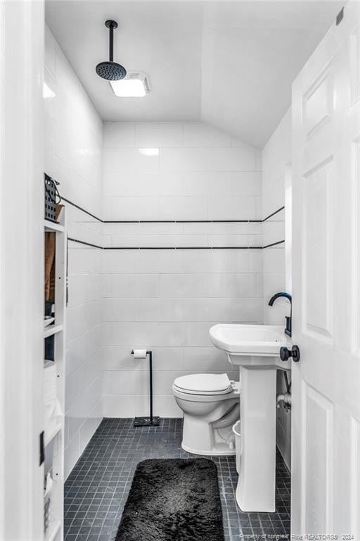 bathroom featuring tile walls, vaulted ceiling, toilet, and tile patterned floors