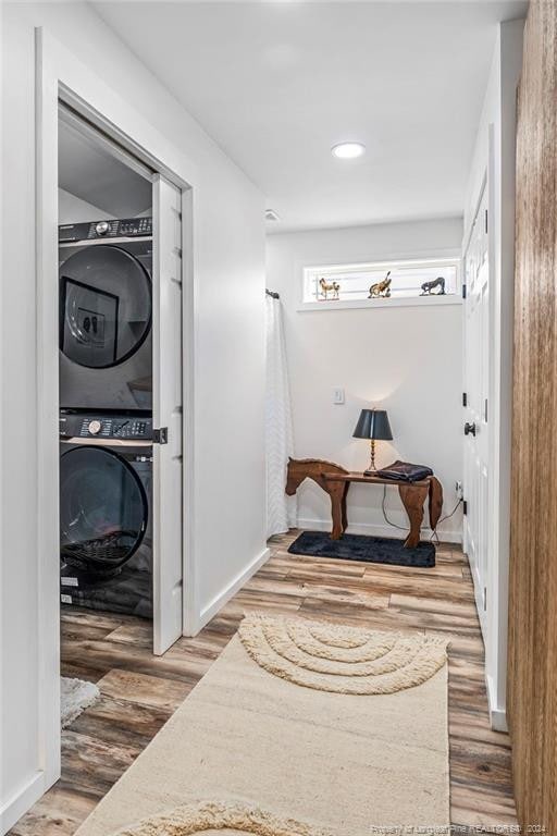 interior space with stacked washer / dryer and wood-type flooring