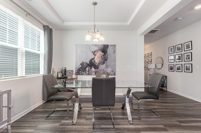 dining space featuring a tray ceiling, a chandelier, and dark hardwood / wood-style floors