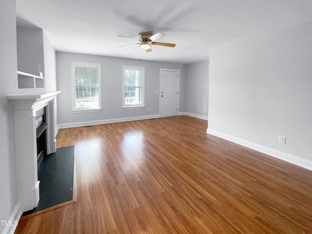 unfurnished living room featuring wood-type flooring and ceiling fan