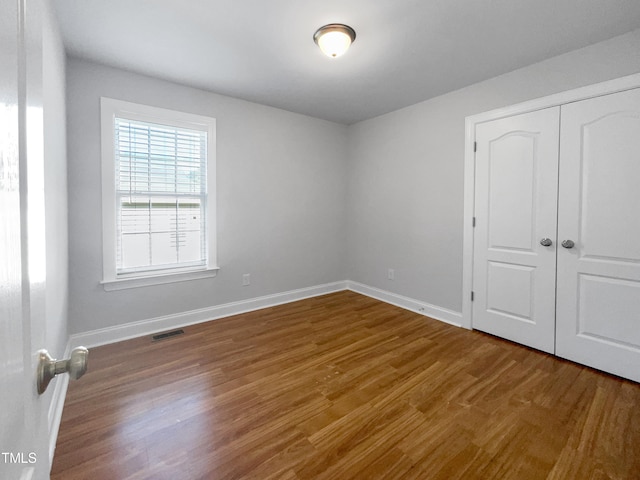 unfurnished bedroom with hardwood / wood-style floors and a closet