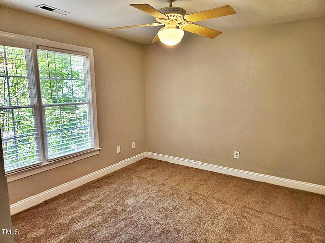 spare room with a healthy amount of sunlight, ceiling fan, and carpet flooring