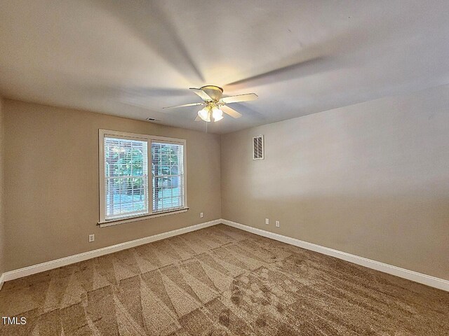 carpeted spare room with ceiling fan