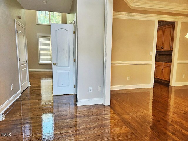 unfurnished room featuring ornamental molding and dark hardwood / wood-style flooring