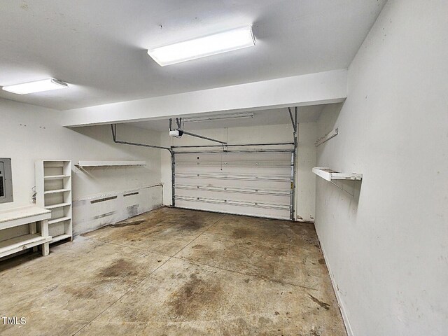 garage with a garage door opener and electric panel