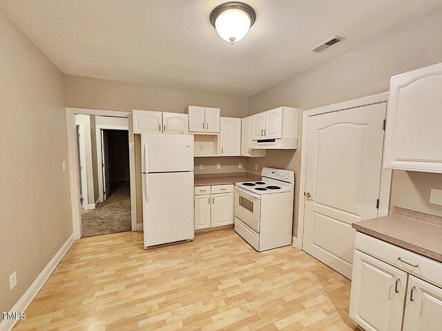 kitchen with white cabinets, white appliances, and light carpet